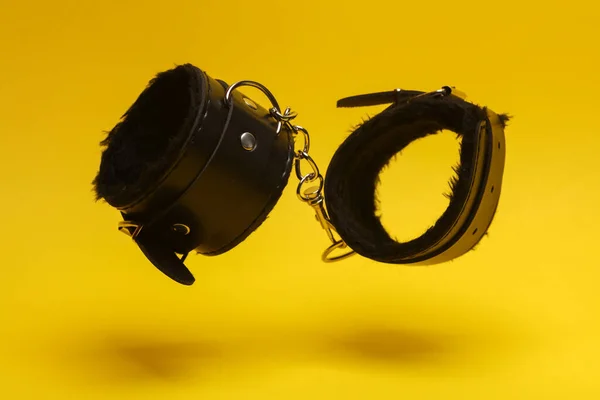 Δερμάτινες Χειροπέδες Bdsm Αιωρείται Κίτρινο Φόντο Κυριαρχία Παιχνίδια Σεξ — Φωτογραφία Αρχείου