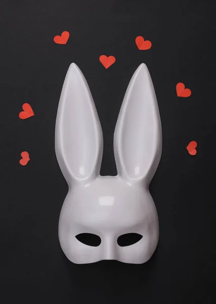 黒い背景にハートのセックスショップから長い耳を持つ白いウサギのマスク セックス愛の概念 — ストック写真