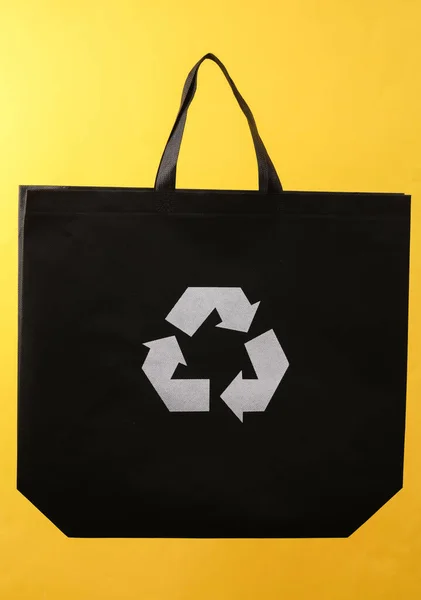 Bolso Negro Con Símbolo Reciclaje Circular Sobre Fondo Amarillo — Foto de Stock