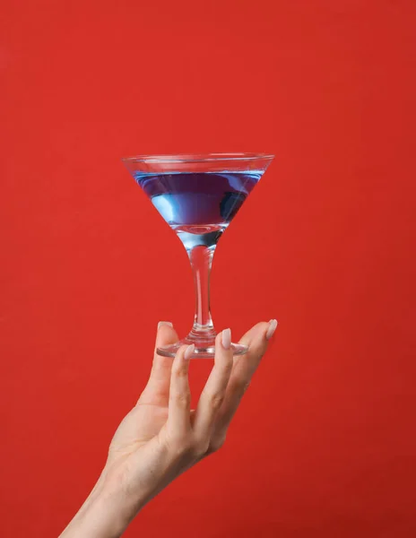 Weibliche Hand Hält Glas Mit Blauem Lagunencocktail Auf Rotem Hintergrund — Stockfoto