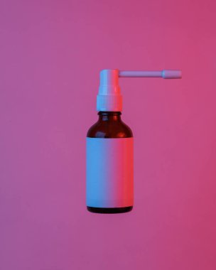 Gırtlak spreyi şişesi havada süzülüyor, mavi-kırmızı neon ışıkta izole edilmiş. Uçan nesneler. Asgari konsept