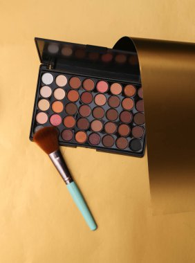Altın sarısı bir arka planda göz farı paleti.