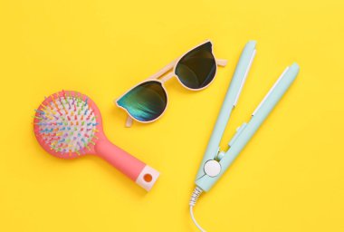 Sarı arka planda kadın aksesuarları. Saç bakımı. Üst Manzara. Düz yatıyordu