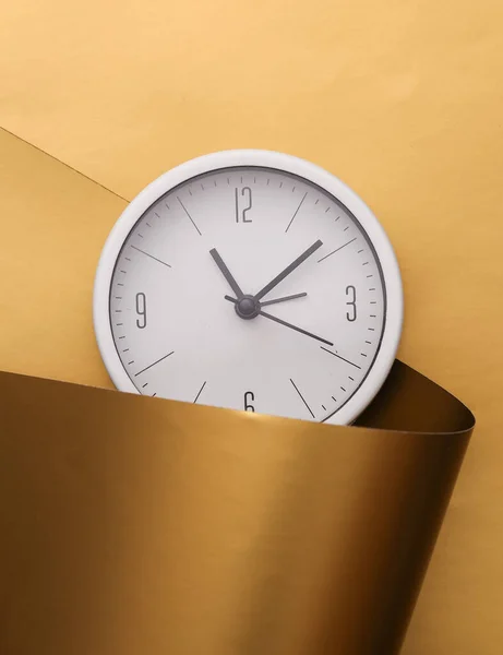 Round clock on a luxurious golden background.