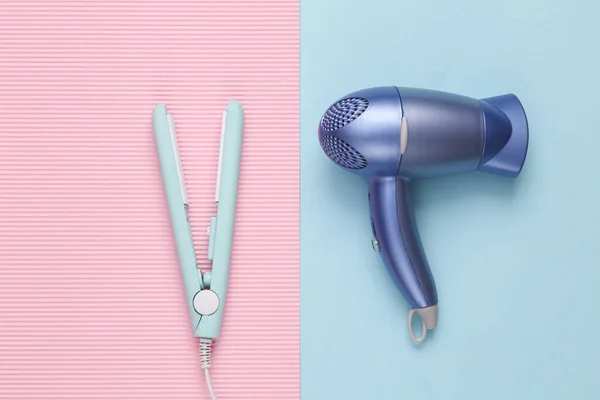 Hair straightener with hair dryer on a blue background. Hair style. Top view