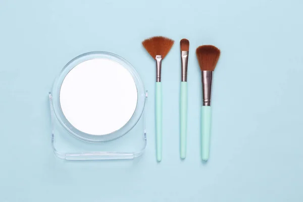 Mavi Arkaplanda Aynalı Makyaj Fırçaları — Stok fotoğraf