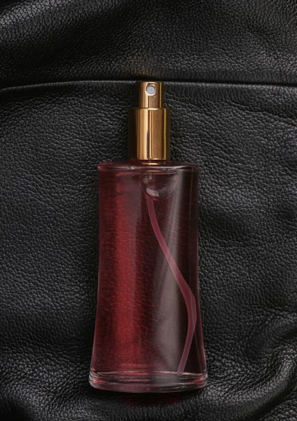 Parfümflasche Auf Schwarzer Lederoberfläche — Stockfoto