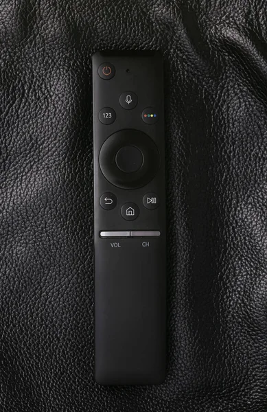 stock image Remote control on black leather surface close up