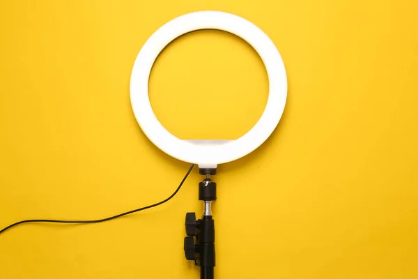 Led ring lamp on yellow background. Gear for blogging and vlogging. Top view