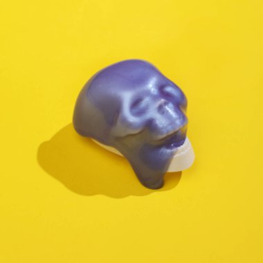 Korkutucu kafatası ve parlak sarı arka planda balçık olan yaratıcı bir düzen. Görsel trend. Cadılar Bayramı konsepti Minimalist estetik, gölgeli bir hayat. Yeni fikir.