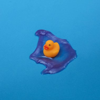 Ördek yavrusu ve balçık ile yaratıcı bir düzen. Parlak mavi arka plan. Görsel trend. Minimalist estetik natürmort. Yeni fikir.