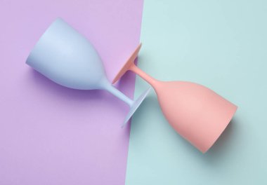 Pastel arka planda plastik şarap bardakları. Üst görünüm