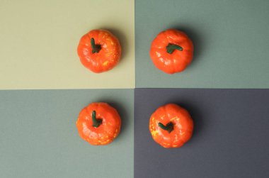 Dört tonlu yeşil arka planda Cadılar Bayramı plastik balkabakları. Şeker mi şaka mı? Üst görünüm