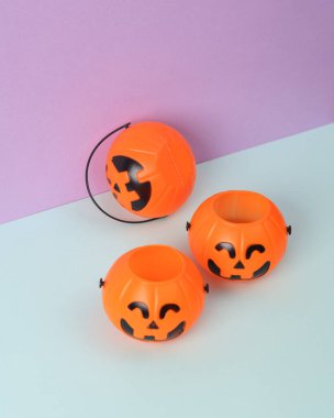 Pastel arka planda Cadılar Bayramı kovaları. En az cadılar bayramı hala hayattadır. Yaratıcı düzen. Şeker mi şaka mı?