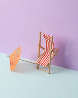 Güverte sandalyesi ve pastel arka planda kokteyl şemsiyesi olan yaratıcı yaz düzeni. Kavramsal patlama. En az yaşam süresi
