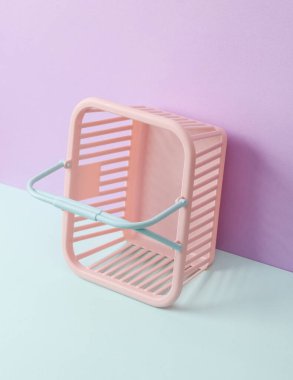 Pastel arka planda alışveriş sepeti olan yaratıcı güzellik düzeni. Kavramsal patlama. Minimum moda hala hayat.