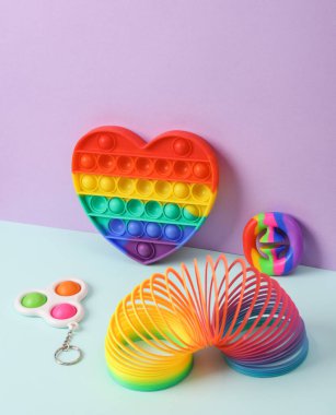 Pastel arka planda stres önleyici oyuncaklar olan yaratıcı bir düzen. Kavramsal patlama. En az yaşam süresi