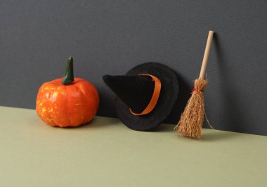 Yaratıcı cadılar bayramı planı. Cadı şapkası, balkabağı ve süpürge iki ton arkaplanda. Kavramsal patlama. Minimal natürmort. Şaka mı şeker mi?