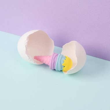 Yaratıcı düzen. İki ton pastel arka planda yumurta kabuklu oyuncak dondurma. Kavramsal patlama. En az besin hala hayatta.