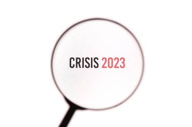 Kriz 2023 beyaz ekran arka planındaki bir büyüteçle. Ekonomi, iş konsepti