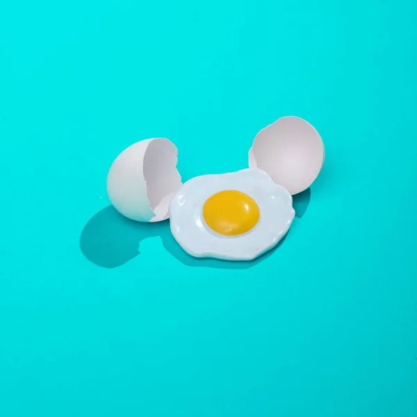 Kırık Kabuklu Parlak Mavi Arka Planlı Yaratıcı Bir Yumurta Tasarımı — Stok fotoğraf