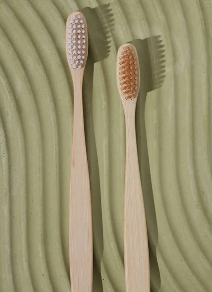Eco bamboo toothbrushes on a green plaster platform. Eco, dental care concept. Top view