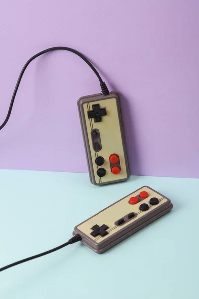 stock image Creative retro 80s layout with old gamepads on pastel background. Conceptual pop. Minimal still life. Video game concept