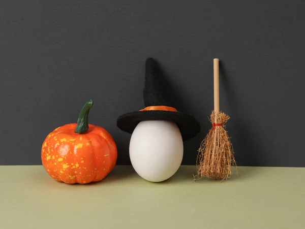 創造的なハロウィーンのレイアウト 2つのトーンの背景に魔女の帽子 カボチャとほうきで卵 概念的なポップ 最小限の静物 — ストック写真