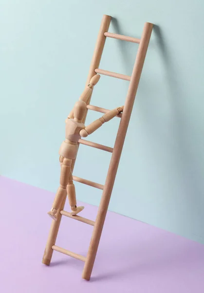 Puppet climbs up on Wooden ladder, pastel background. Leadership, career growth, business concept. Creative minimal layout