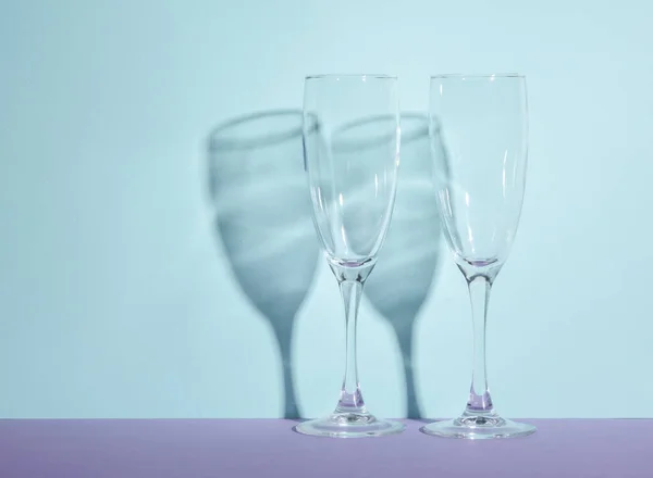 stock image Creative layout with empty champagne glass on two tone pastel background. Visual trend. Minimalistic aesthetic still life. Reflection, shadows