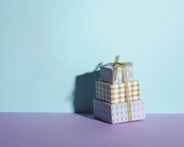 一堆堆礼品盒贴在有阴影的彩色背景上 最小的圣诞节布置 — 图库照片