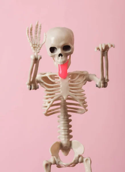 Skeleton with slime in the mouth on pink background. Fresh idea. Minimalism halloween concept