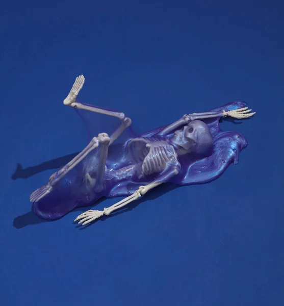 創造的なハロウィーンのレイアウト 影の濃い青の背景にスライム付きスケルトン 視覚的な傾向 新鮮なアイデアだ コンセプトポップ — ストック写真