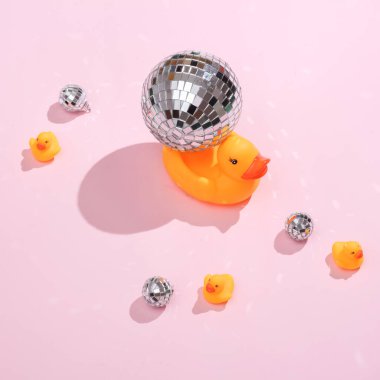 Yaratıcı tıp düzeni. Pembe arka planda disko topları olan lastik ördekler. 80 'lerin retroestetiği. Gerçeküstü bir fikir. Parti konsepti. Kavramsal pop