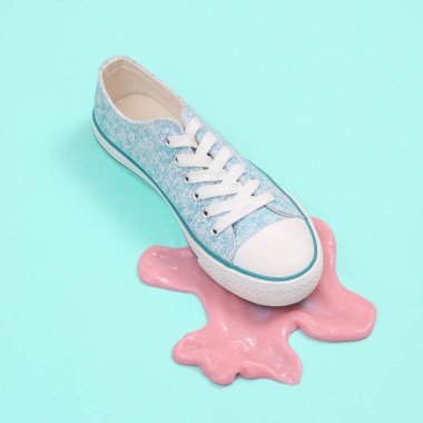 Yaratıcı minimalist düzen. Mavi arka planda sümüksü bir spor ayakkabı. Gerçeküstü yaz fikri. Kavramsal patlama. Pastel arkaplan.