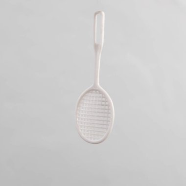 Oyuncak tenis raketi gri arka planda izole edildi