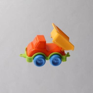 Oyuncak kamyonu gri arka planda uçuyor.