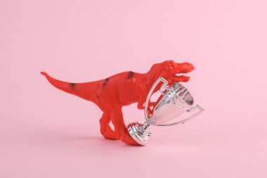 Oyuncak iki dinozor tyrannosaurus rex ve pembe arka planda kupa. Minimalizmin yaratıcı düzeni