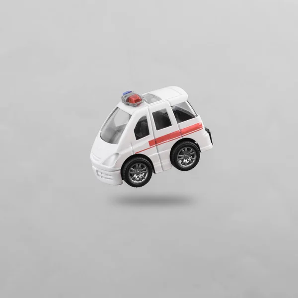 Spielzeug Krankenwagen Schwebt Auf Grauem Hintergrund Mit Schatten — Stockfoto