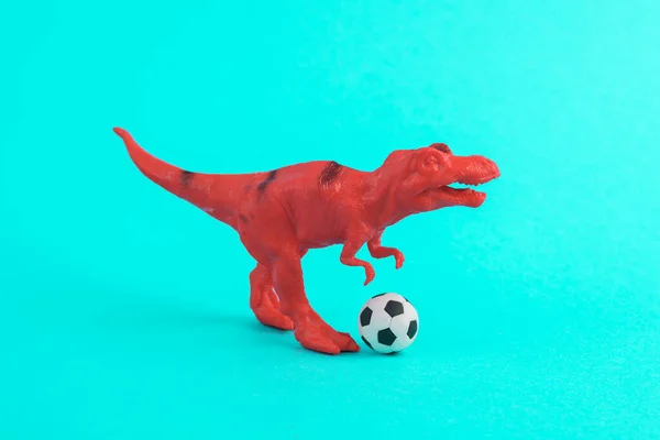 Dinossauro Brinquedo Tyrannosaurus Rex Com Bola Futebol Fundo Turquesa Layout — Fotografia de Stock