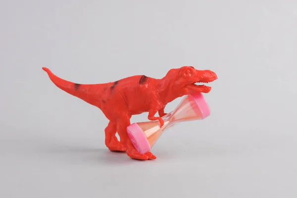 Brinquedo Dois Dinossauros Tyrannosaurus Rex Com Ampulheta Fundo Cinza Layout — Fotografia de Stock