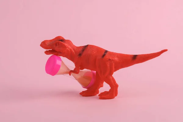 Игрушка Два Динозавра Тираннозавр Рекс Песочными Часами Розовом Фоне Креативная — стоковое фото
