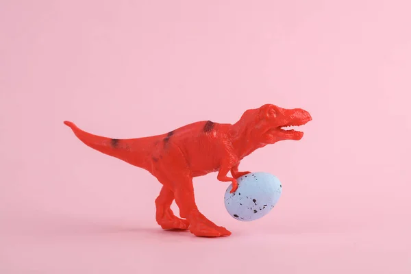 玩具红色恐龙霸王龙雷克斯与东方蛋粉红背景 简约主义创意布局 — 图库照片