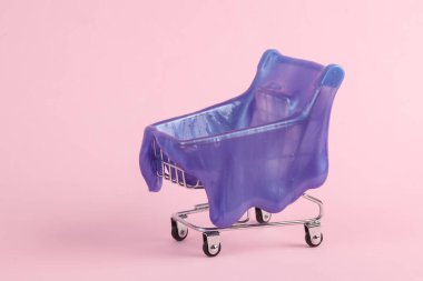 Pembe arka planda sümüklü süpermarket arabası. Yaratıcı cadılar bayramı düzeni