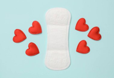 Mavi arka planda kalpleri olan bir ped. Kadınsı mahrem hijyen kavramı