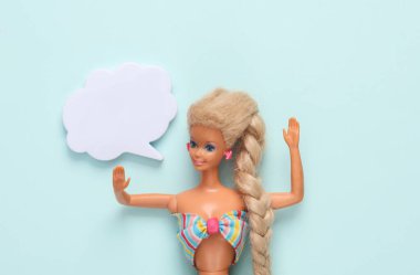 ODESSA, UKRAINE - 28 HAZİRAN 2022: Mavi arka planda konuşma balonu olan Barbie bebek