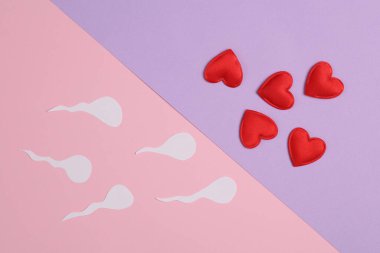 Spermatozoa with hearts on a pastel background. Love, conception, sex concept clipart