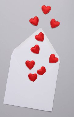 Gri arka planda kalpleri olan beyaz bir zarf. Aşk, romantizm, Sevgililer Günü, 14 Şubat konsepti