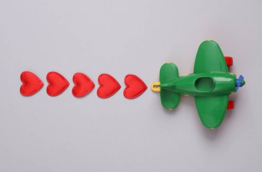 Kalpleri gri arka planda olan oyuncak uçak. Aşk, romantizm, Sevgililer Günü, 14 Şubat konsepti