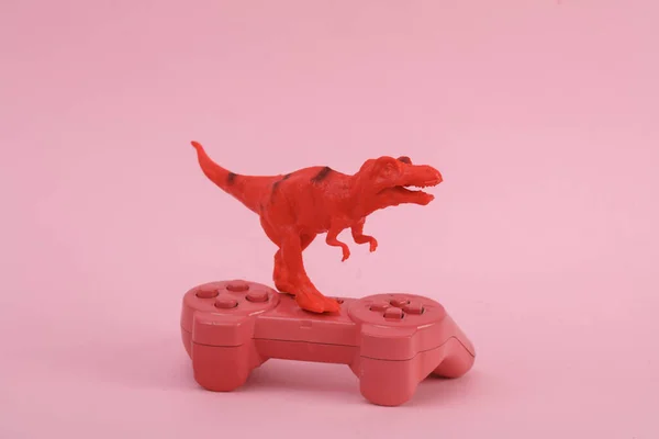 Toy Dinossauro Tyrannosaurus Rex Com Gamepad Fundo Rosa Layout Criativo — Fotografia de Stock